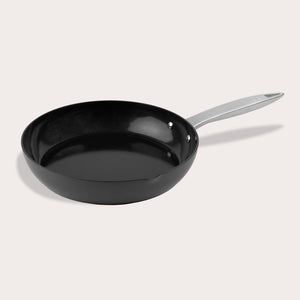 The Zyliss Ultimate Pro Ceramic Fry Pan, black with a silver metal handle, is displayed empty on a plain white background. The pan’s durable non-stick coating is visible as it sits angled with the handle pointing right. #28cm/11"