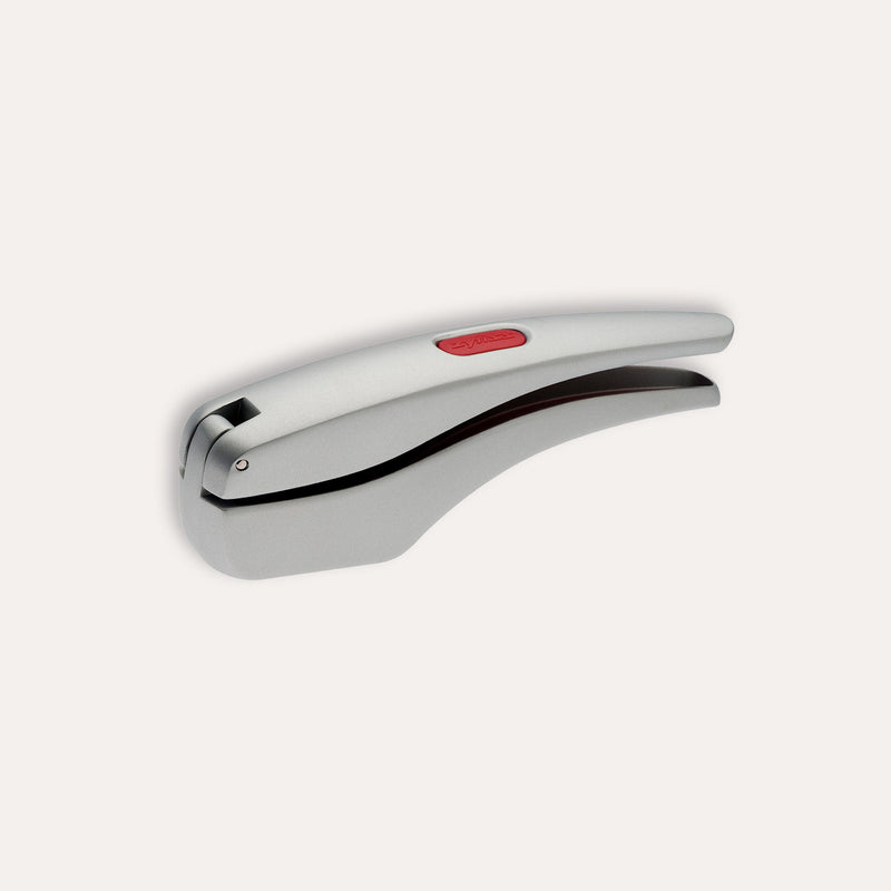The Zyliss Susi 3 Garlic Press, made of stainless steel with an ergonomic handle and red accent, is shown closed on a white background. It’s dishwasher safe for easy cleaning.