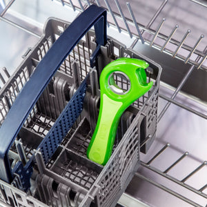 A green plastic wrench rests inside the cutlery basket of an empty dishwasher, with silver racks visible in the background.