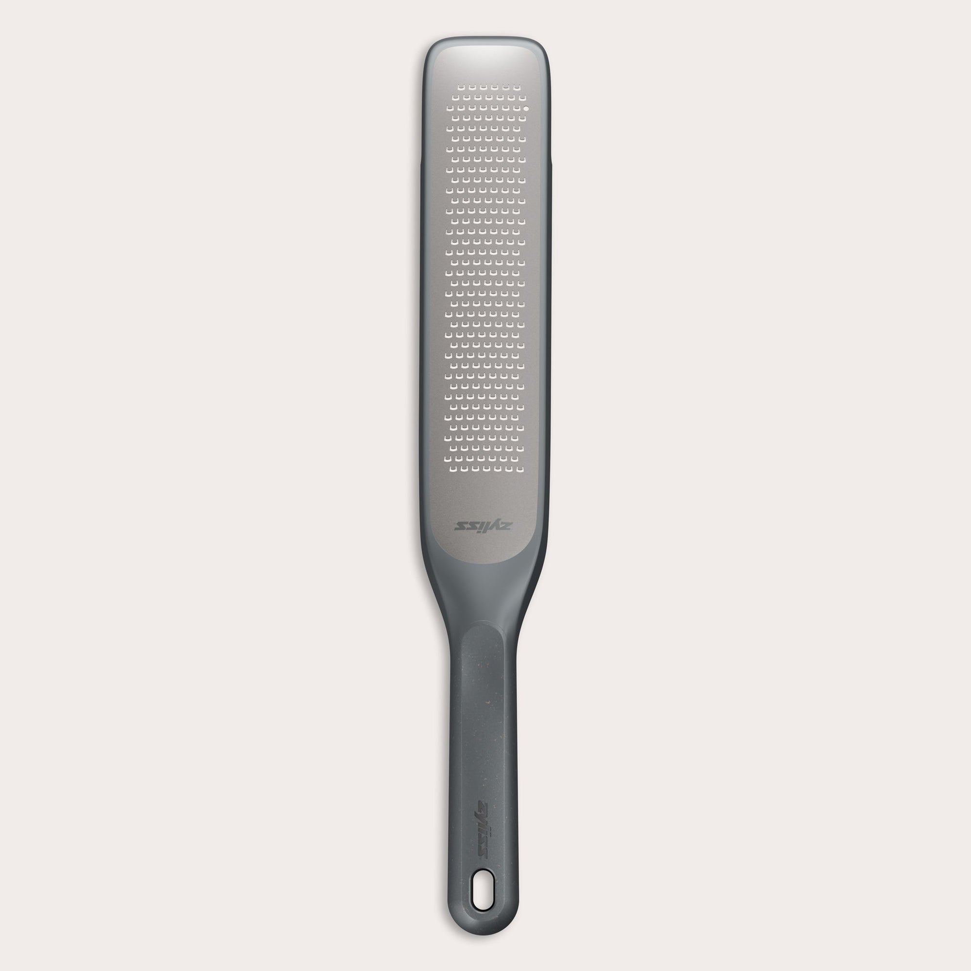 #belugagrey The Zyliss Rasp Grater is a long, rectangular foot file with a gray handle and textured metal surface for removing calluses and dead skin. The handle features a hanging hole for easy storage.