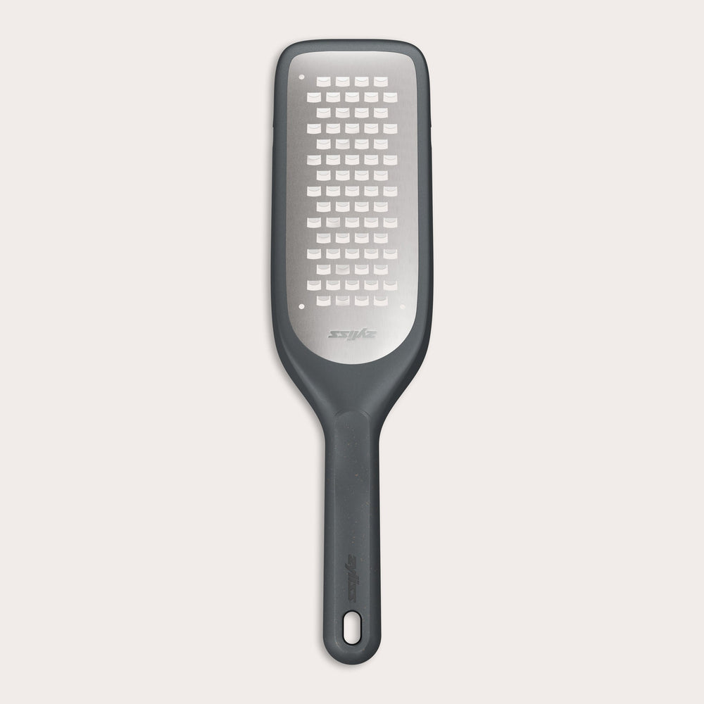 The Zyliss Coarse Grater is a black and silver foot file with a long handle and ultra-sharp grater surface, designed to efficiently remove dead skin from feet.