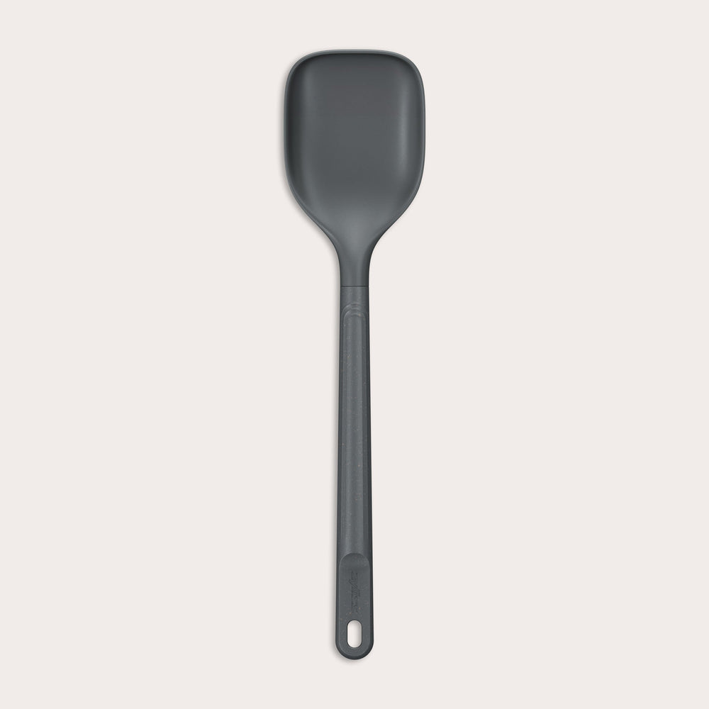 #large A durable Zyliss Spoon in dark gray silicone, featuring a long handle with a hole at the end, displayed on a plain light background. #Large