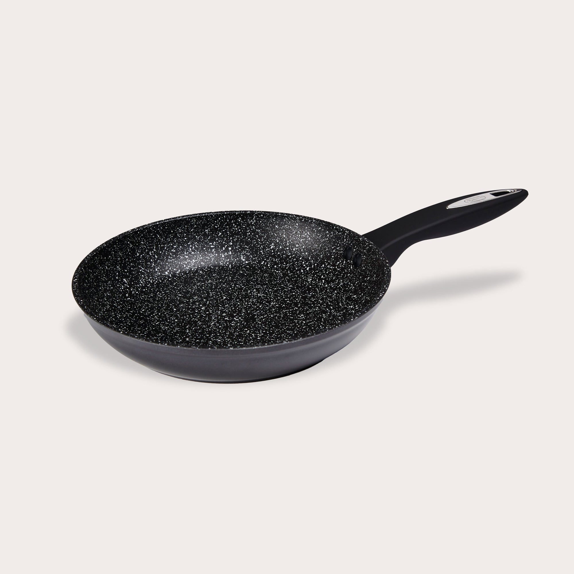 The Zyliss Ultimate Non-Stick Frying Pan features a black scratch-resistant, speckled interior and an ergonomic handle, shown resting on a plain light background. #24cm/9½"